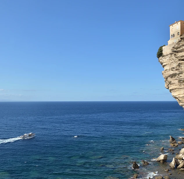 scogliere bonifacio con mare e barca in fondo
