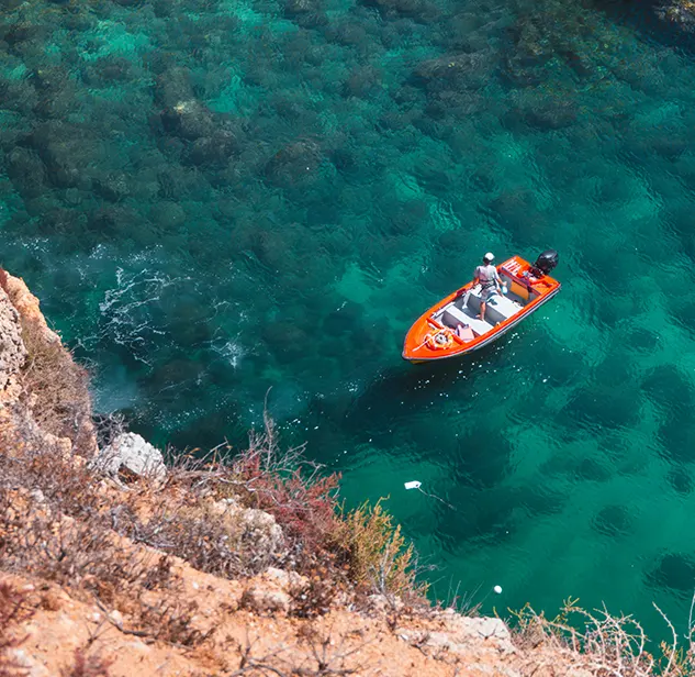 barca arancione on arrivo ad una scogliera nel mare di bonifacio corsica