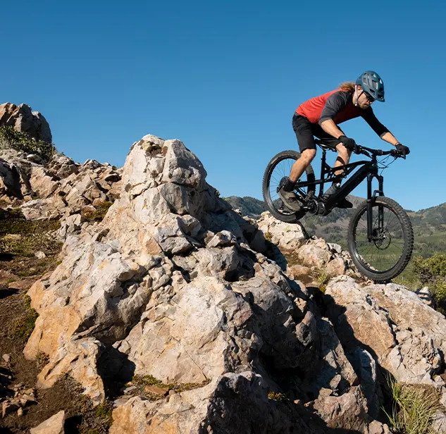 rider balancing on a rocky terrain in his black mountan bike