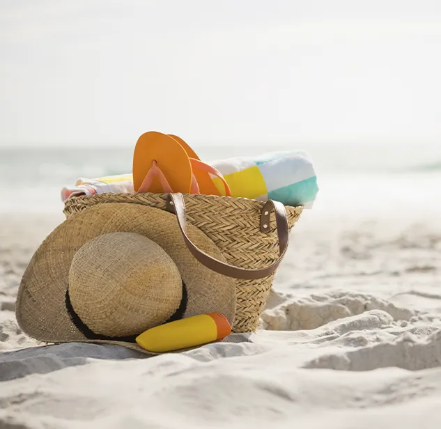 borsa da spiaggia in paglia su spiaggia di sabbia bianca in Sardegna