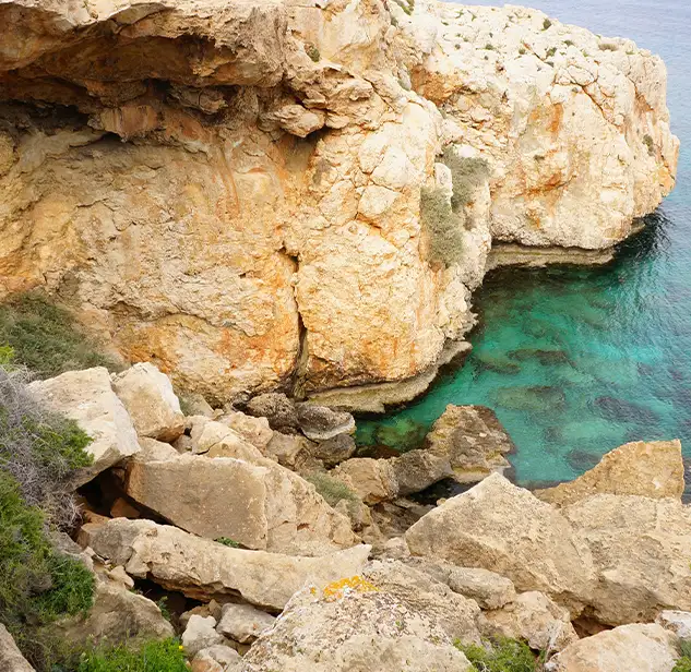 white rock cliff over turquoise waters in the coast of sardinia