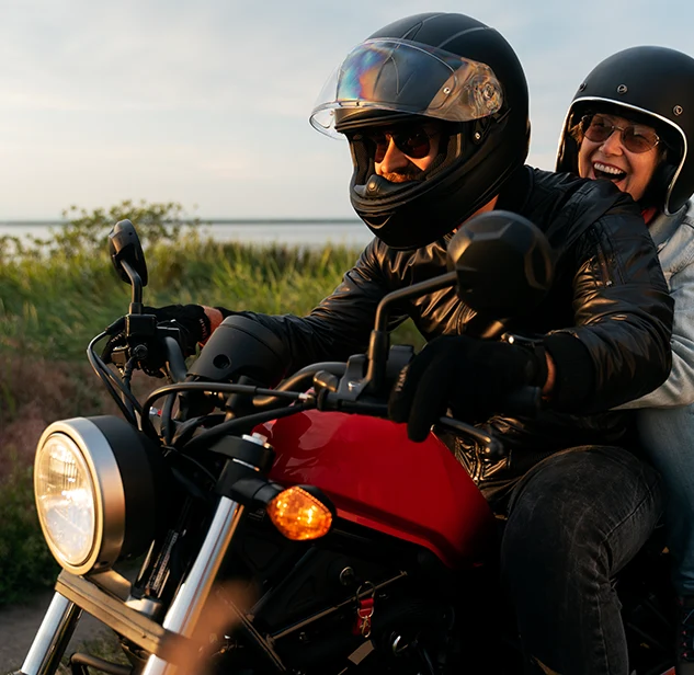 happy couple on a red motorbike during a tour through sardinia