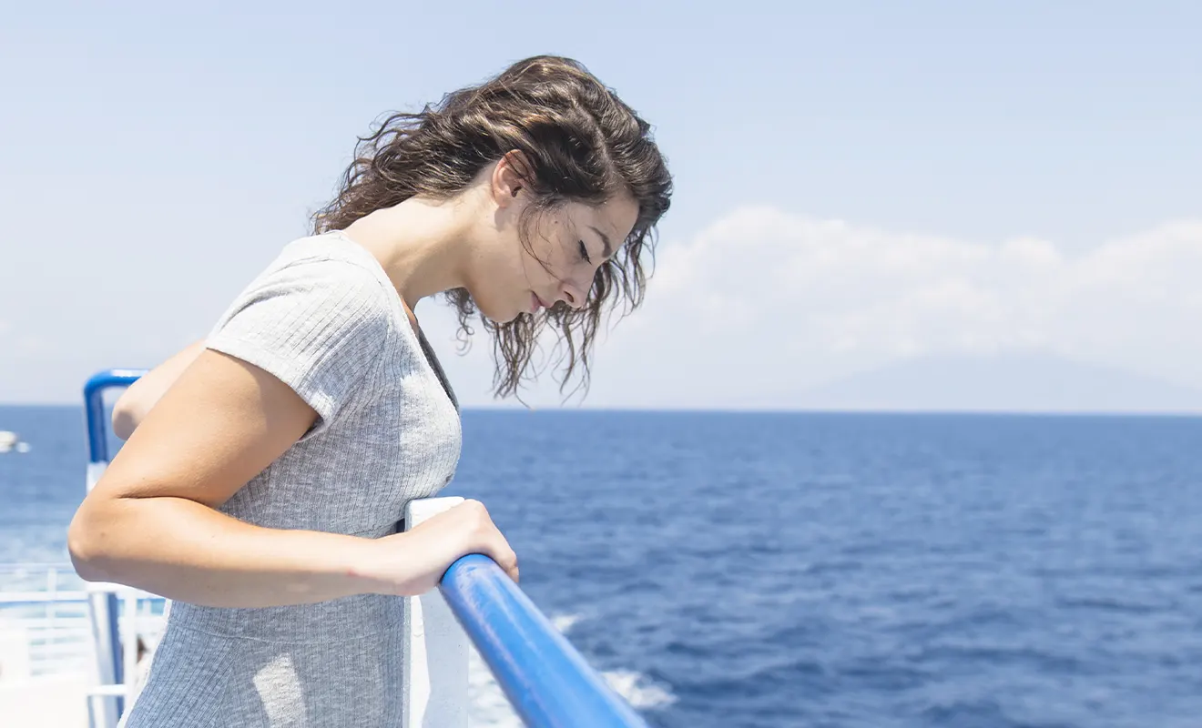girl with seasickness on the outside deck of a ferry
