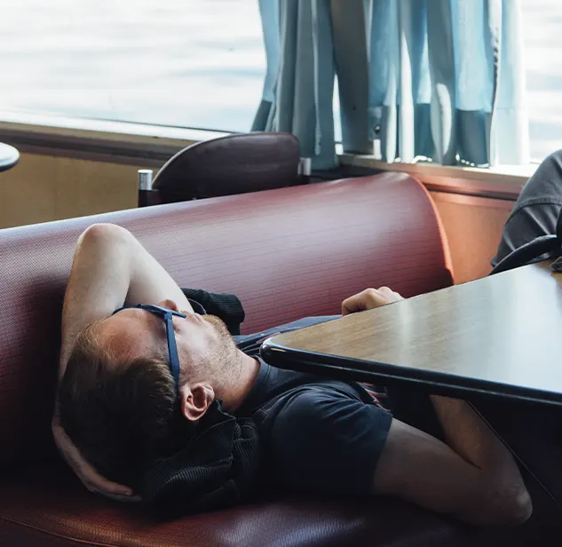 homme en train de se detendre dans siege a l'interieur d'un ferry