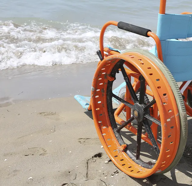 closeup of a wheelchair on the sand of a beach in corsica